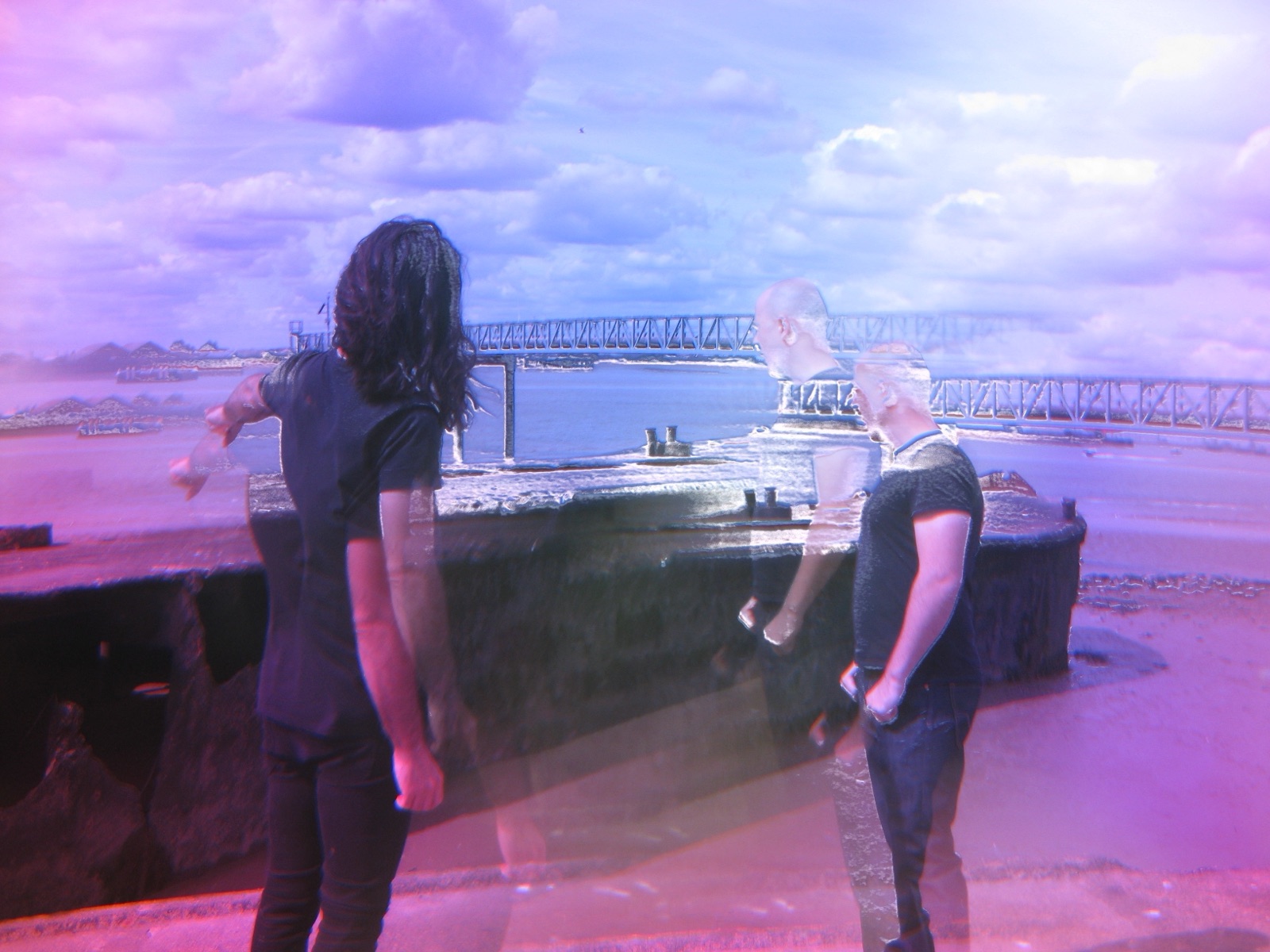 Two musicians occupy a violet waterfront scene while translucent profiles and bodies cross the space between them.