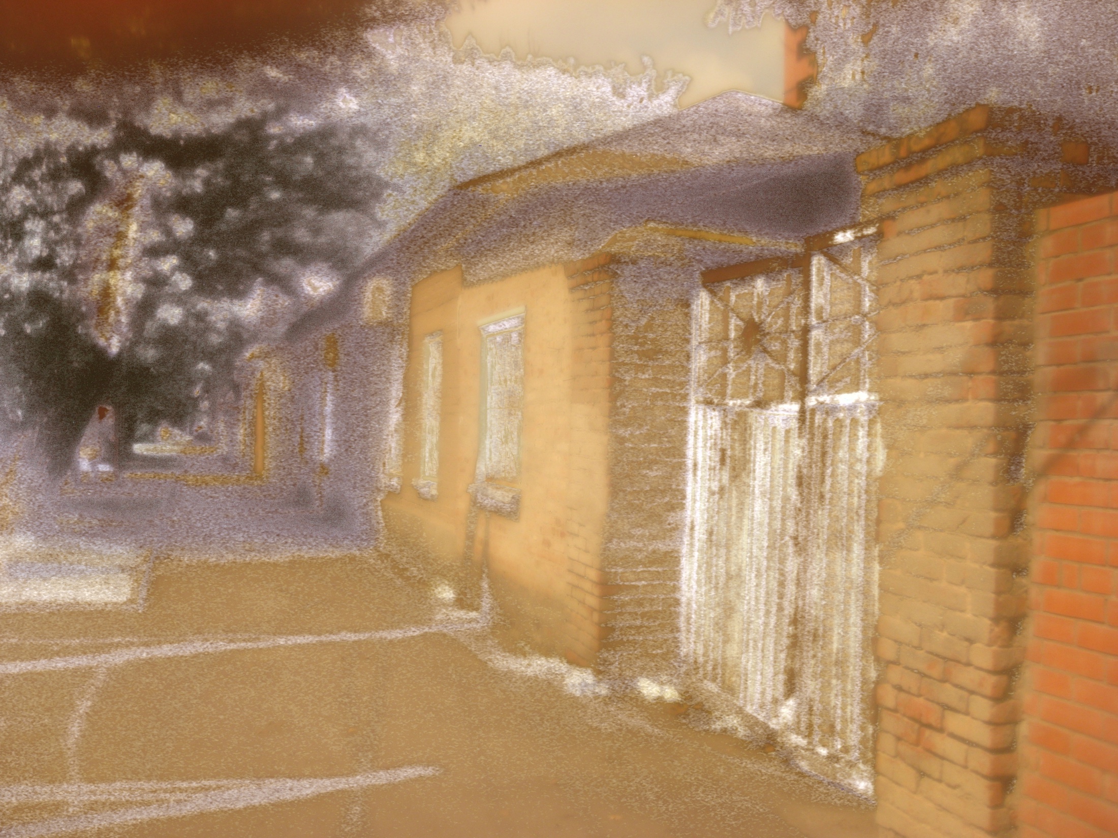 A low house seen through uneven translucent material held before the lens.