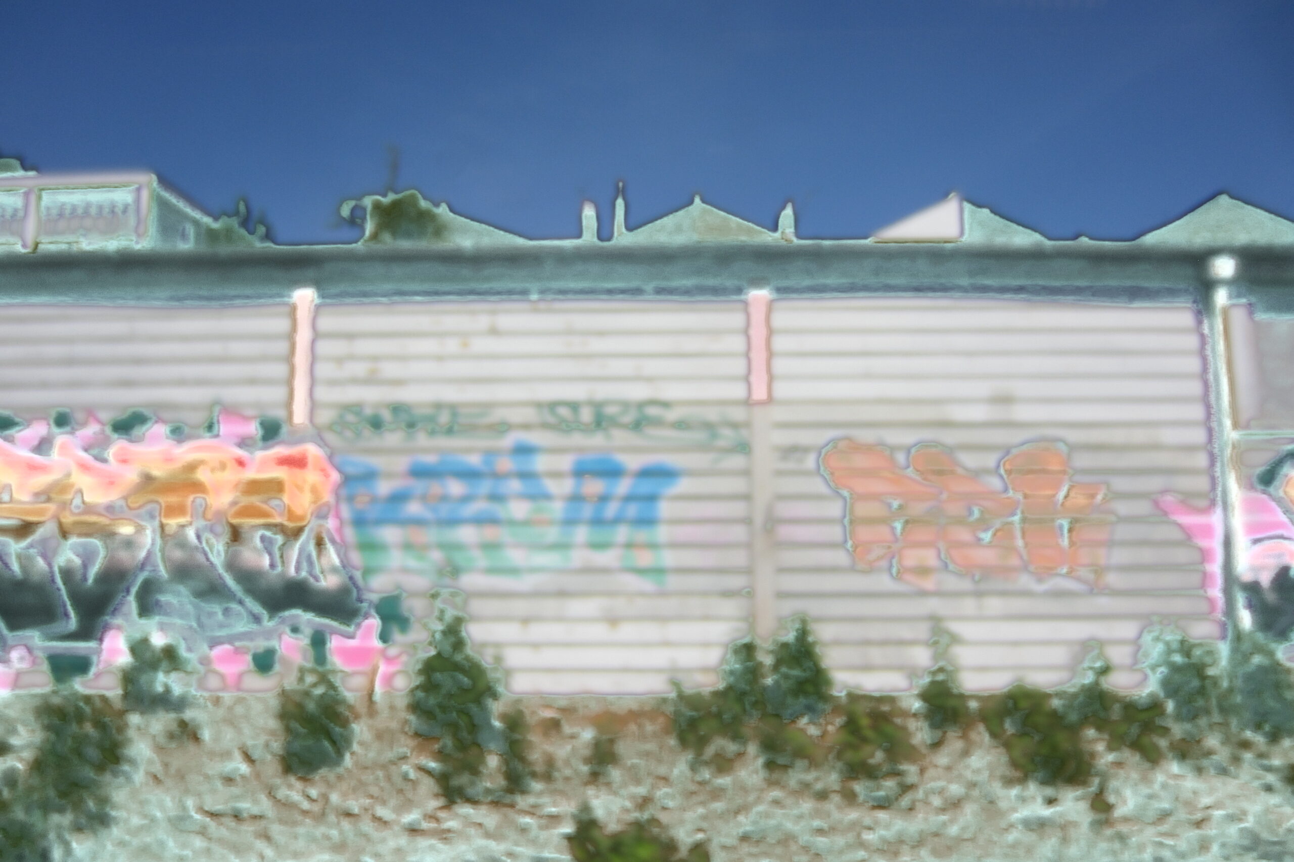 Blurred wall and graffiti translated into pale blue, pink and green.