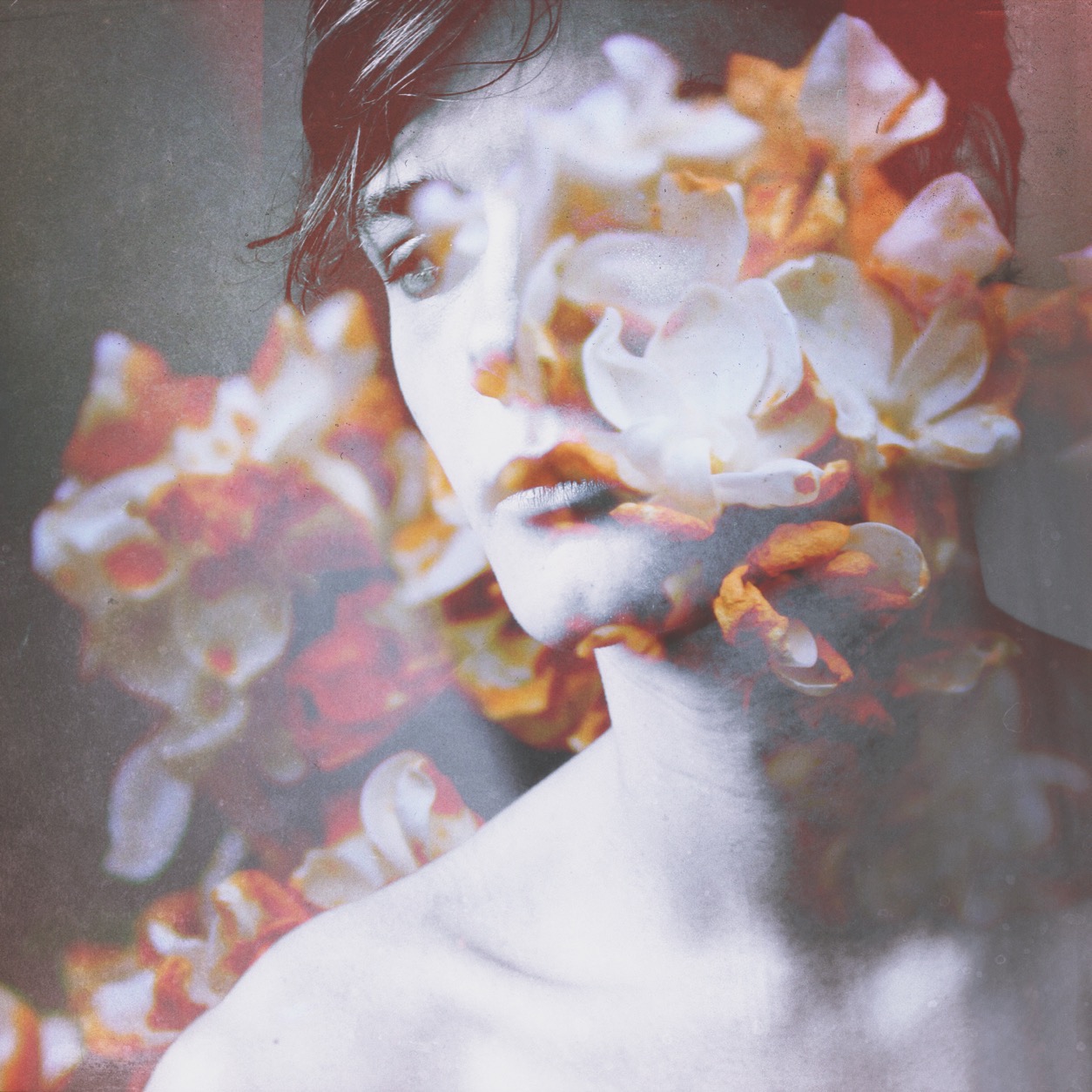 A square portrait with pale petals and warm-toned flowers layered across part of the face.